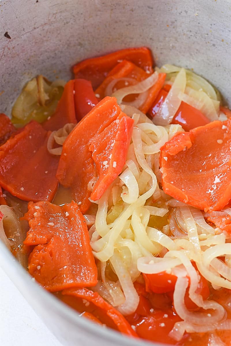 roasted red peppers and onions in a pot.