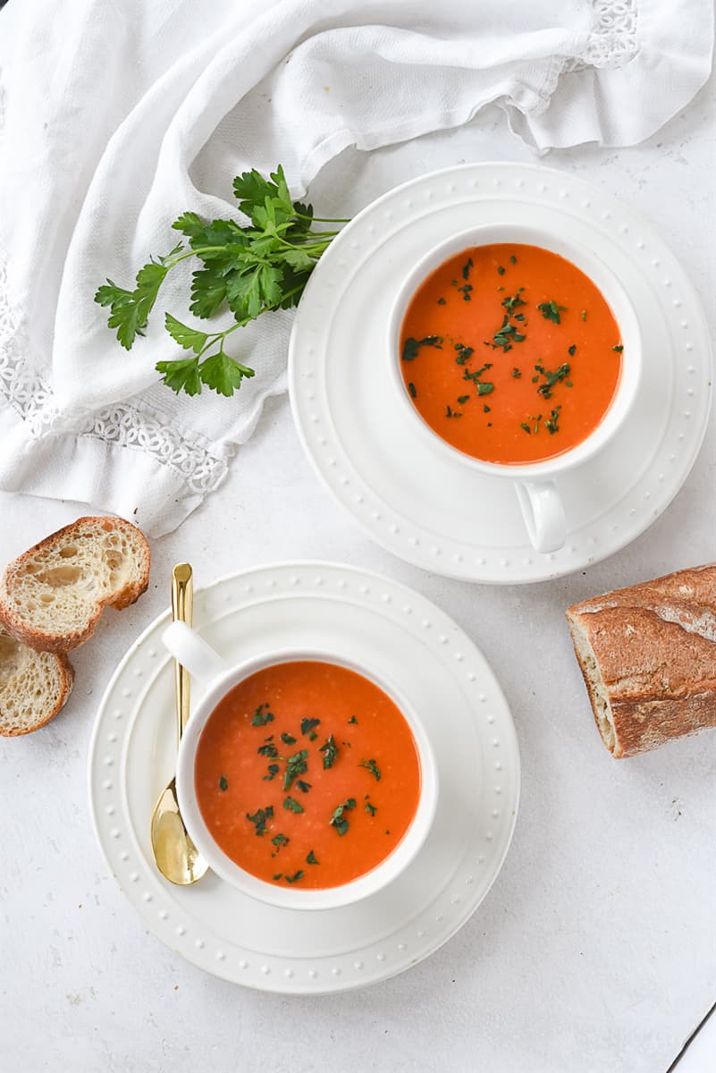 overhead shot of two bowls of roasted red pepper tomato soup