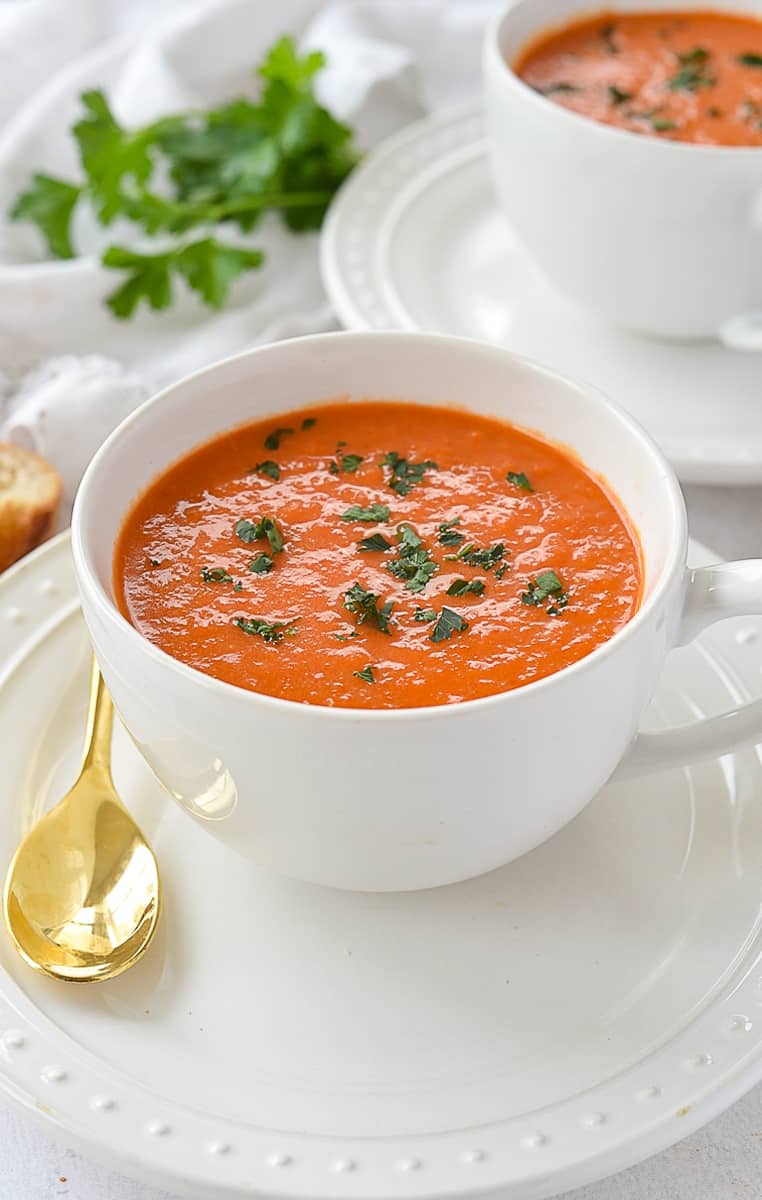 bowl of roasted red pepper soup with parsley on top