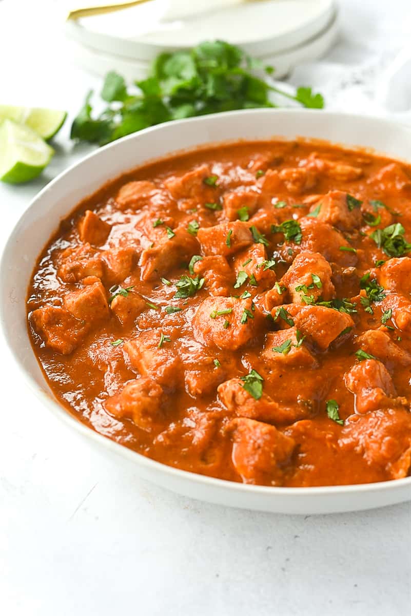 bowl of butter chicken with cilantro on top