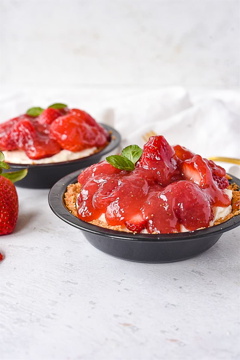 two mini strawberry pies in graham cracker crust