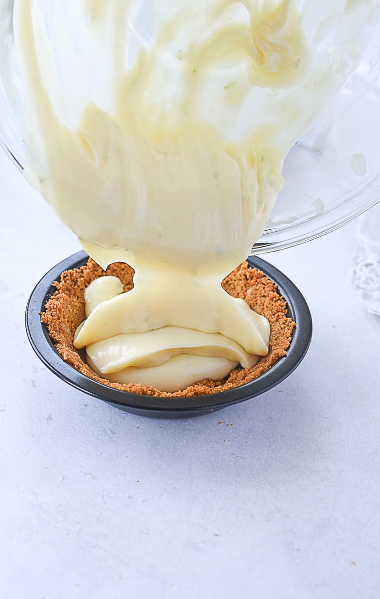 pouring key lime pie filling into crust