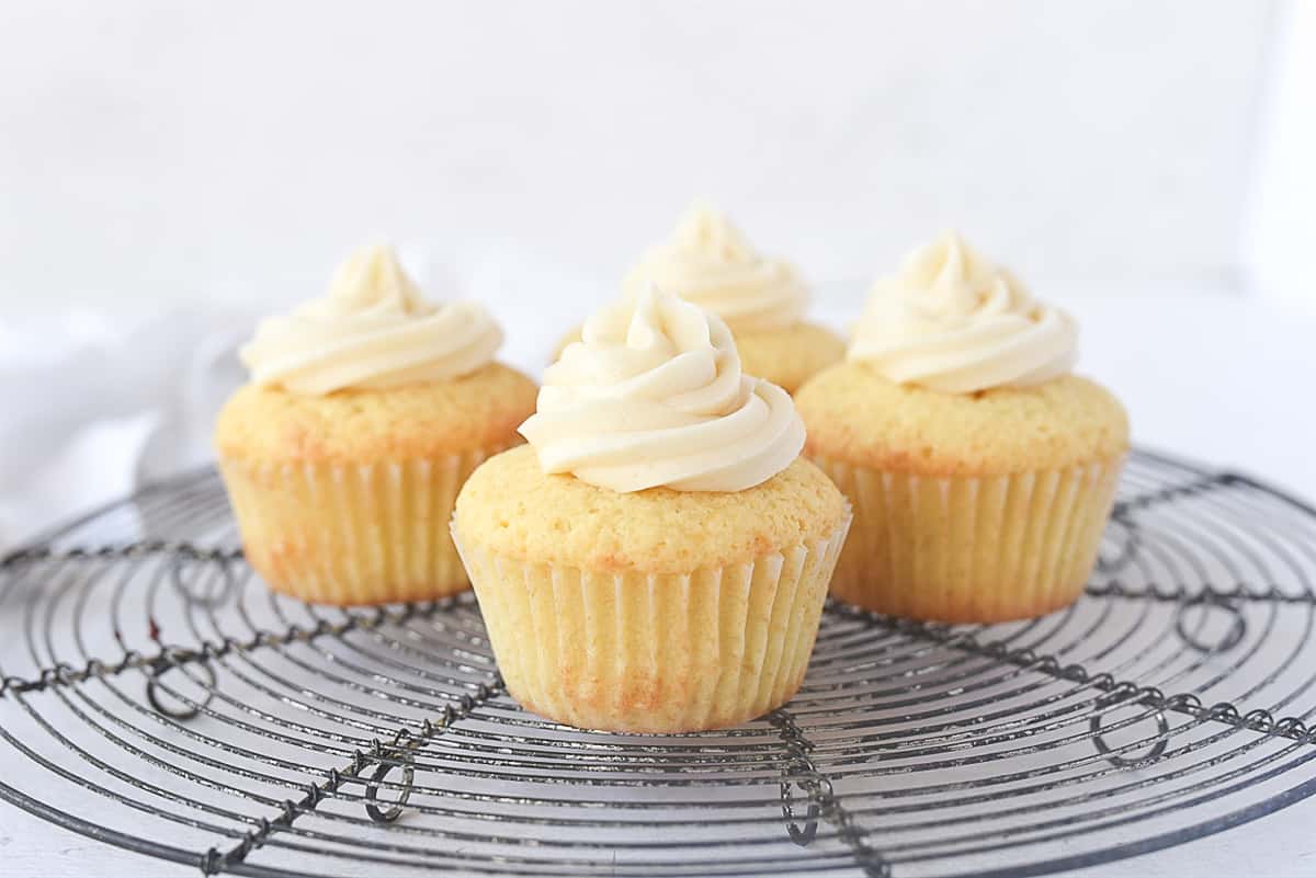 four cupcakes on a cooling rack