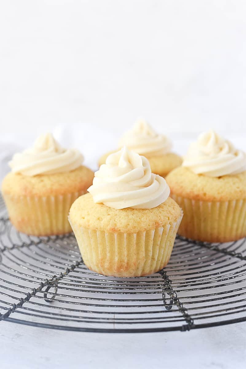 four cupcakes with frosting