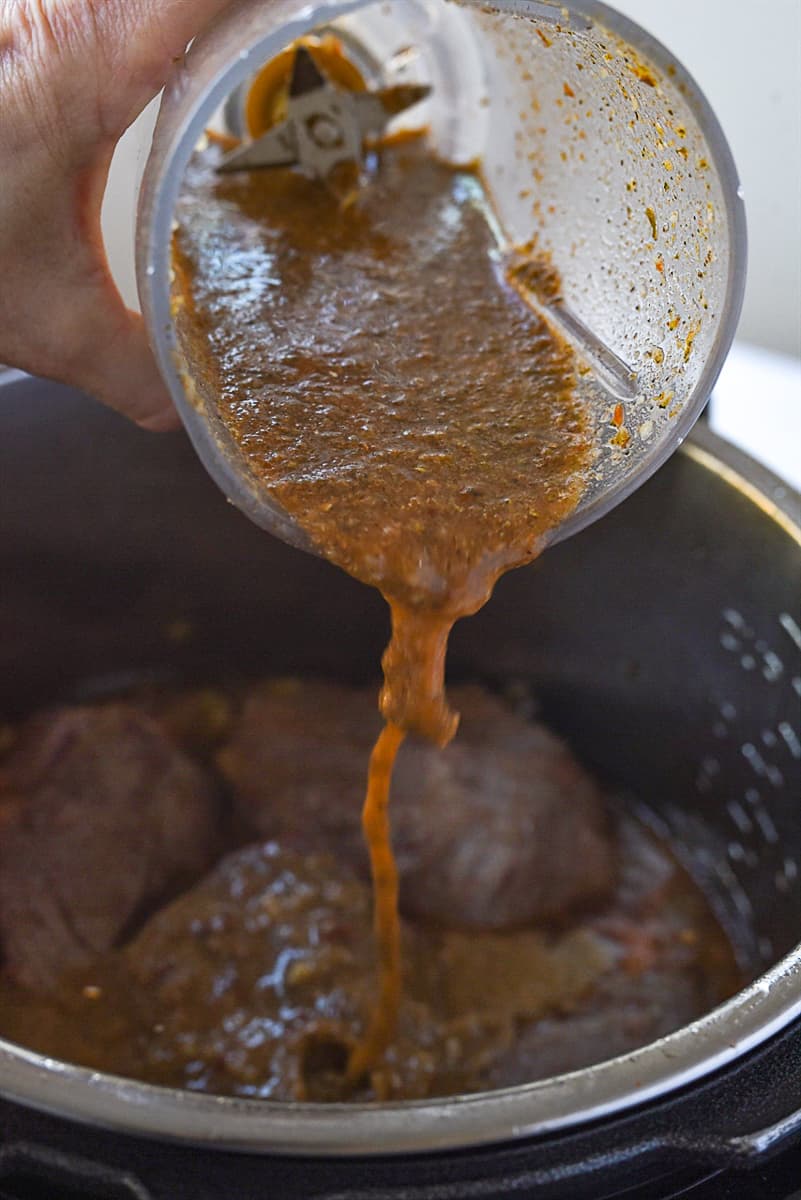 pouring chipotle sauce over meat