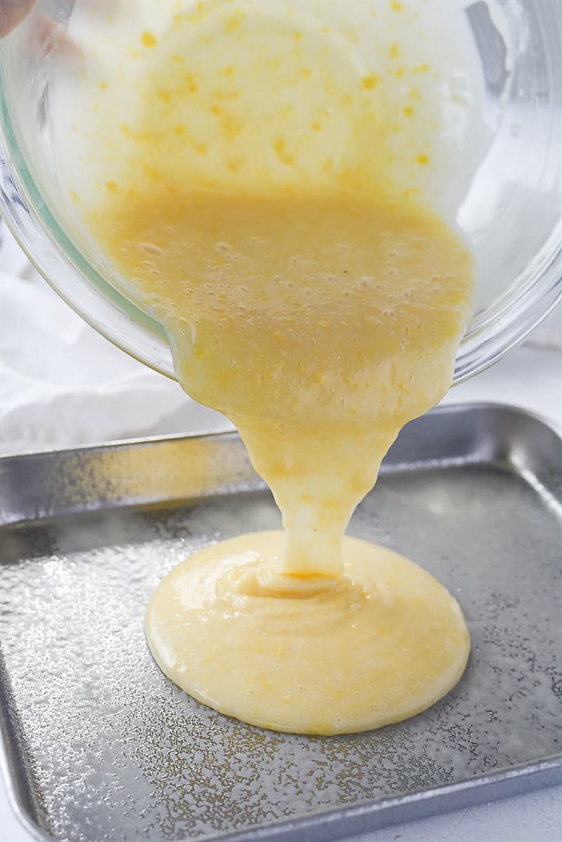 pouring cake batter into pan.