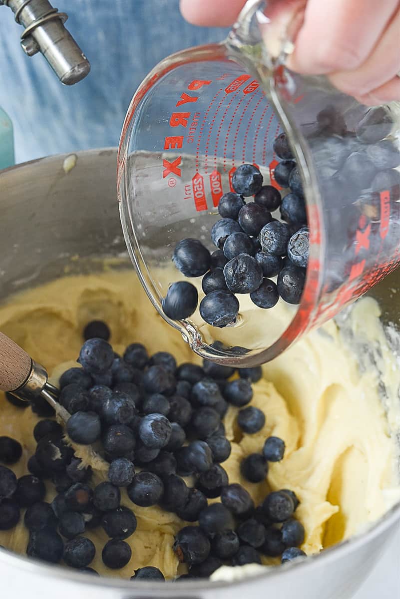 pouring blue berries into cake