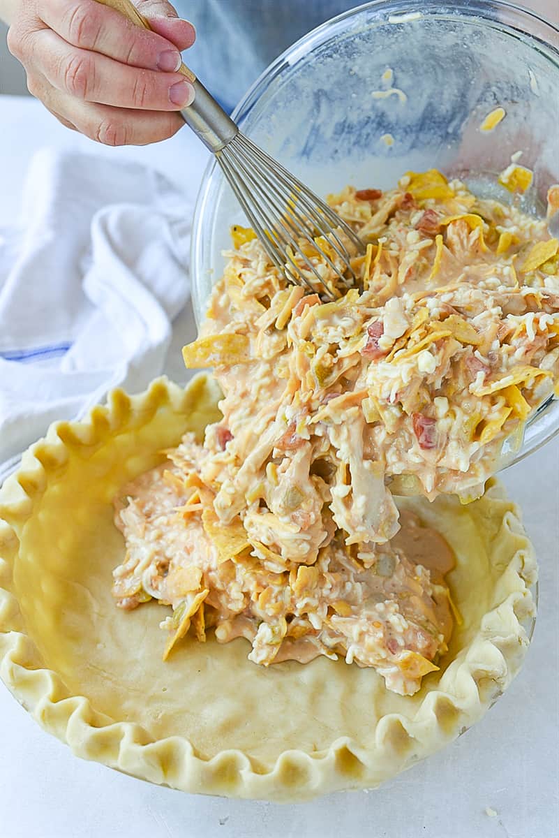 pouring quiche batter into crust