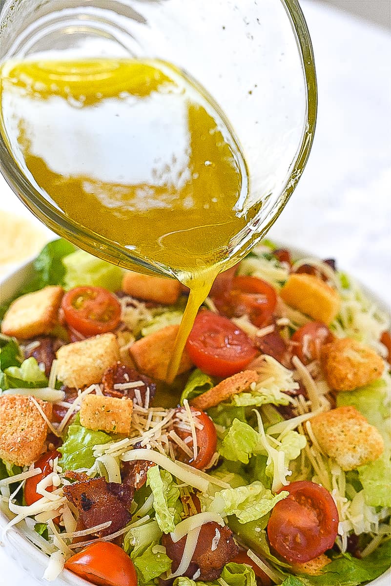 pouring dressing over house salad