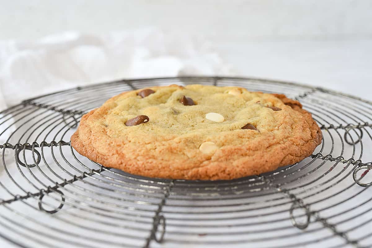 one chocolate chip cookie on a cooling rack