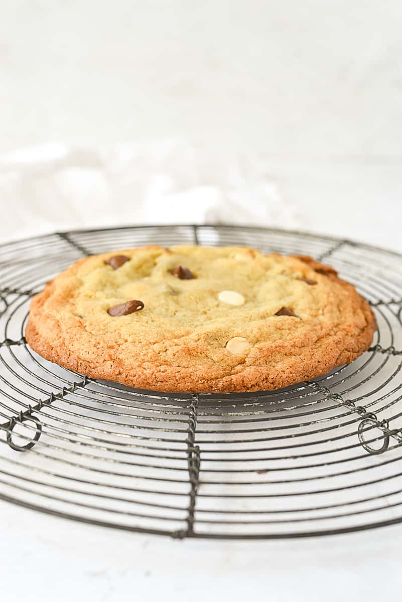 an individual chocolate chip cookie on a cooling rack