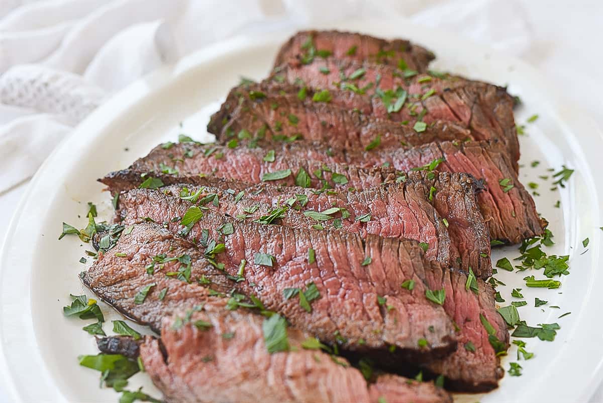 sliced london broil on a white plate