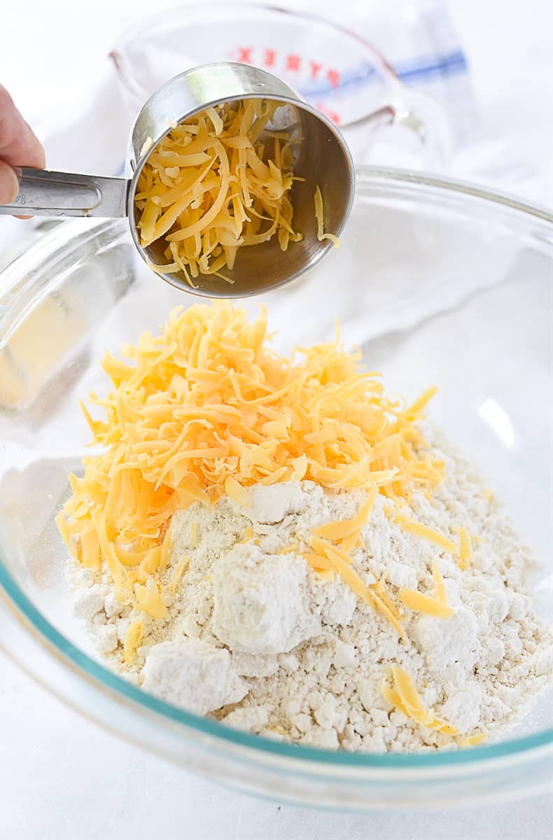 adding cheese to biscuit dough