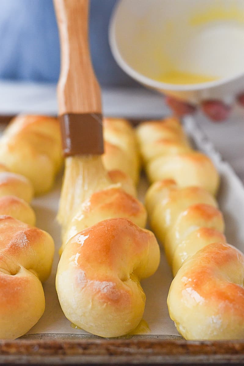 brushing butter on baked breadsticks