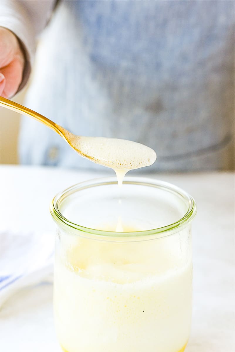 spooning coconut syrup out of jar