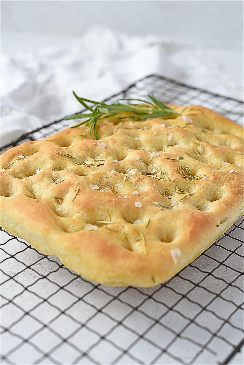 loaf of focaccia bread on a cooling rack