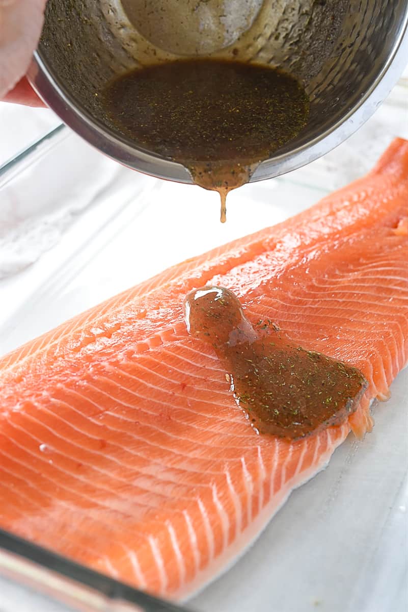 pouring marinade over salmon