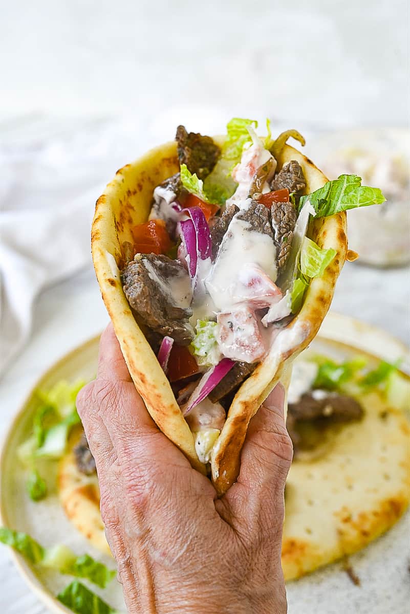 beef gyro hand holding a gyro