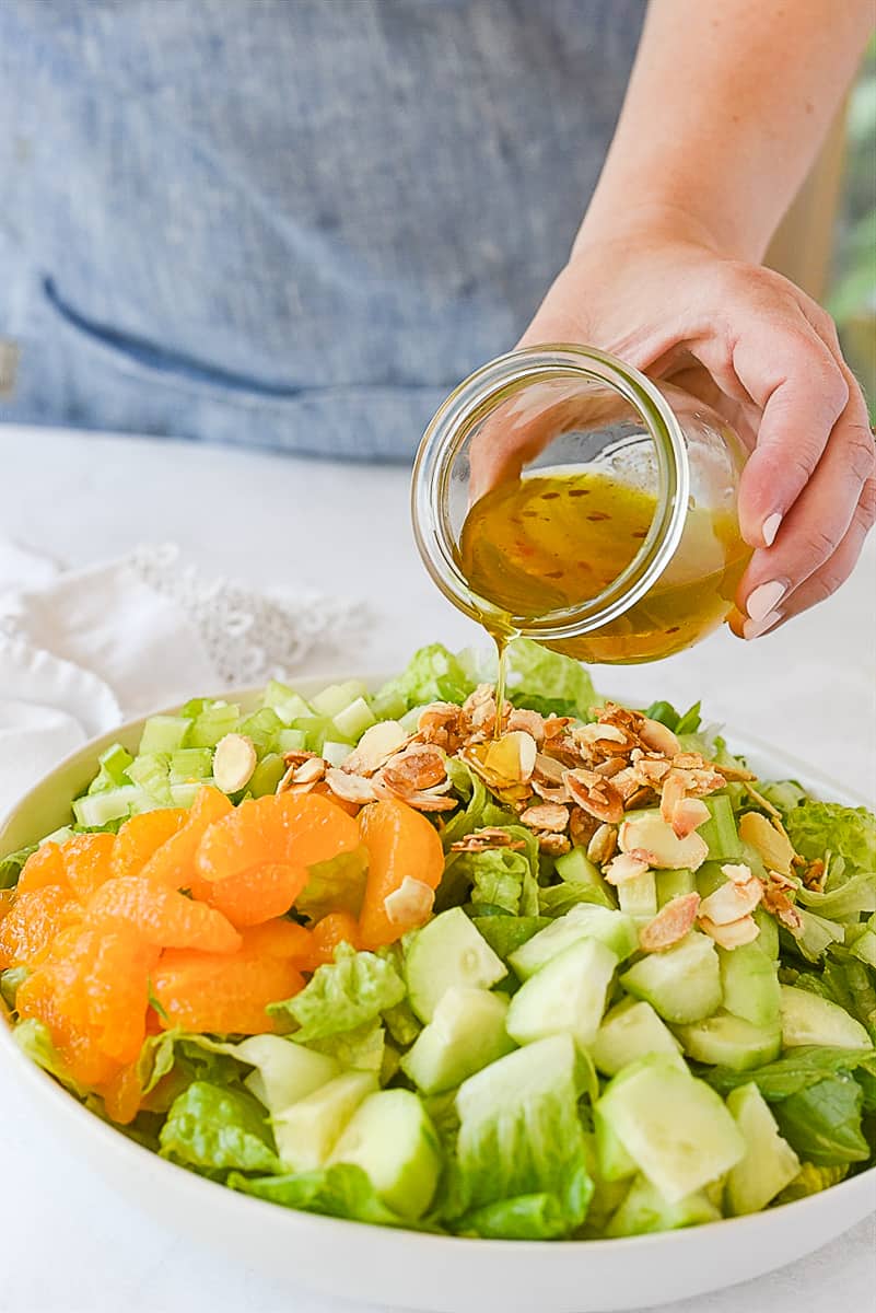 pouring dressing over celestial salad