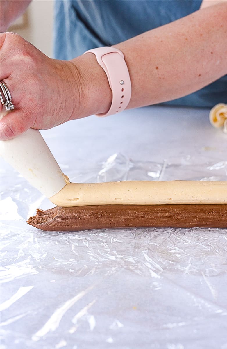 piping frosting onto plastic wrap