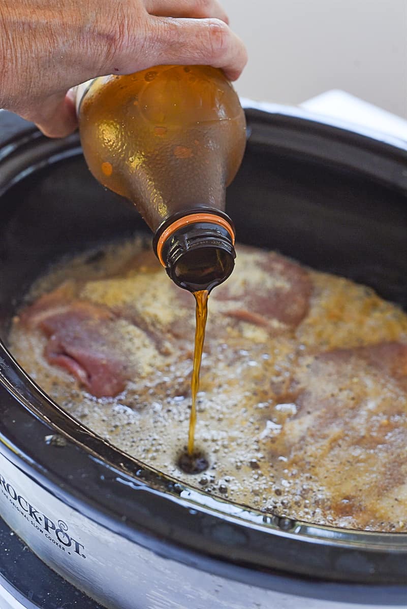 pouring root beer into BBQ pork