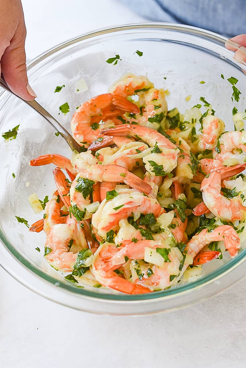 tossing shrimp in herbs