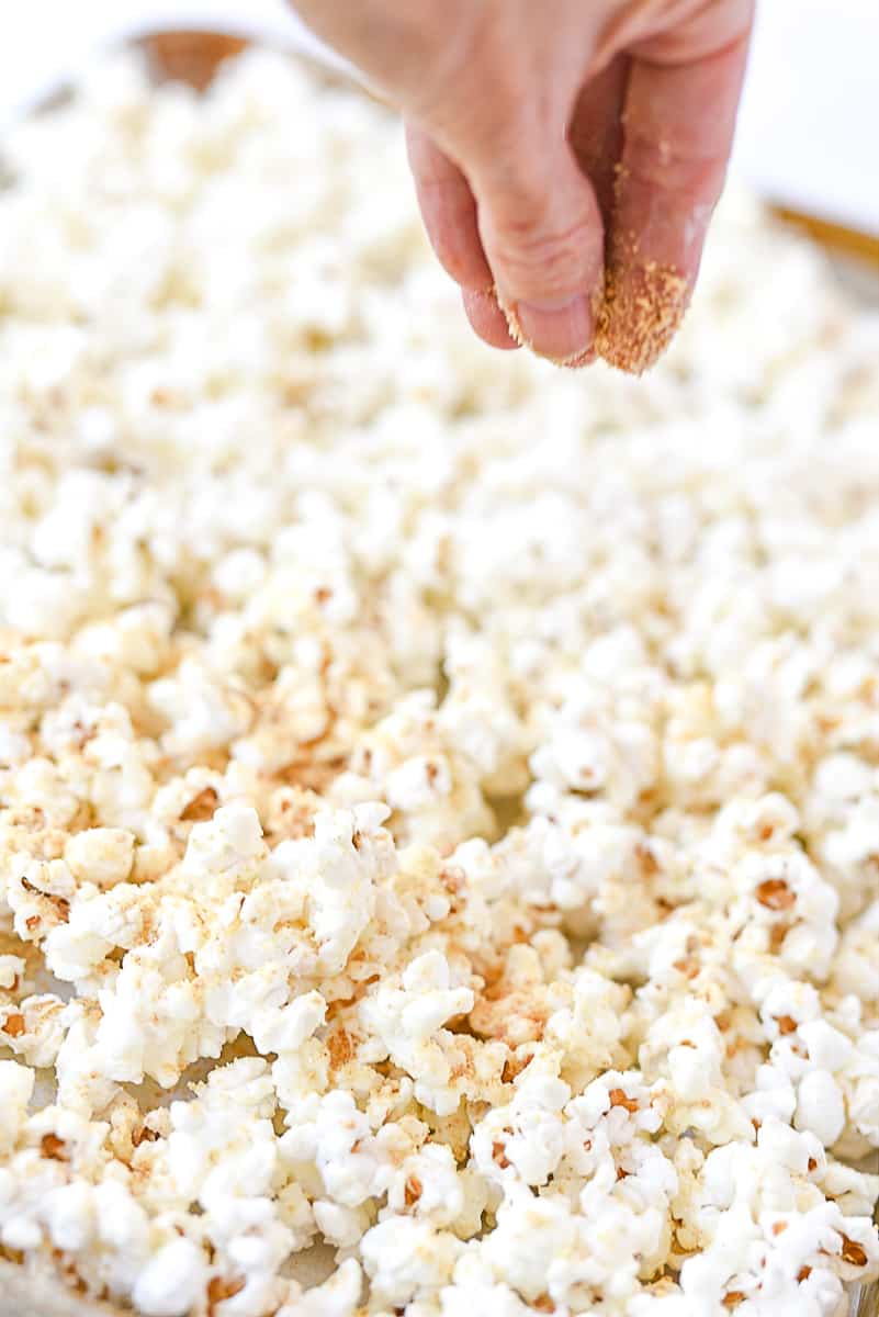 sprinkling graham crackers on popcorn