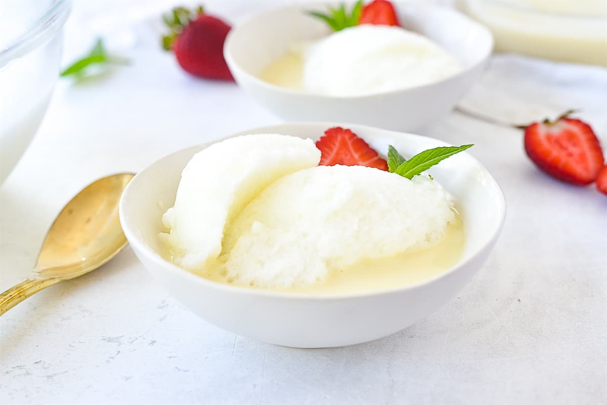 a bowl of snow pudding with a strawberry on it