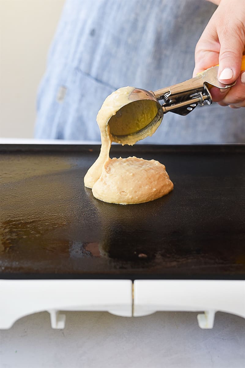 scooping pancakes onto griddle