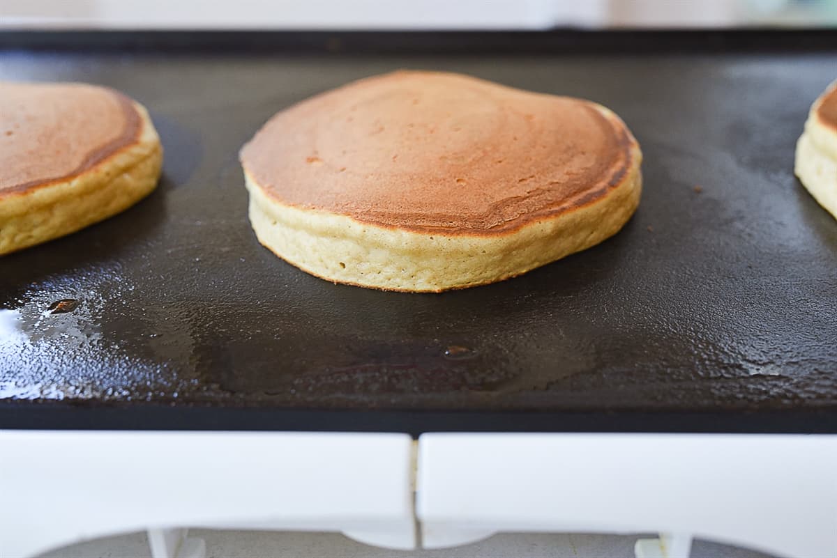 pancakes cooking on griddle