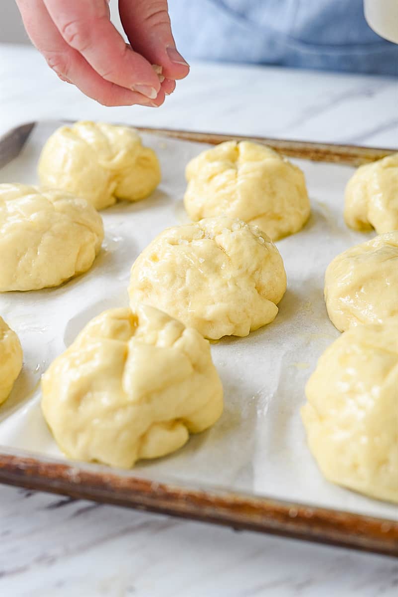 sprinkling pretzel rolls with salt