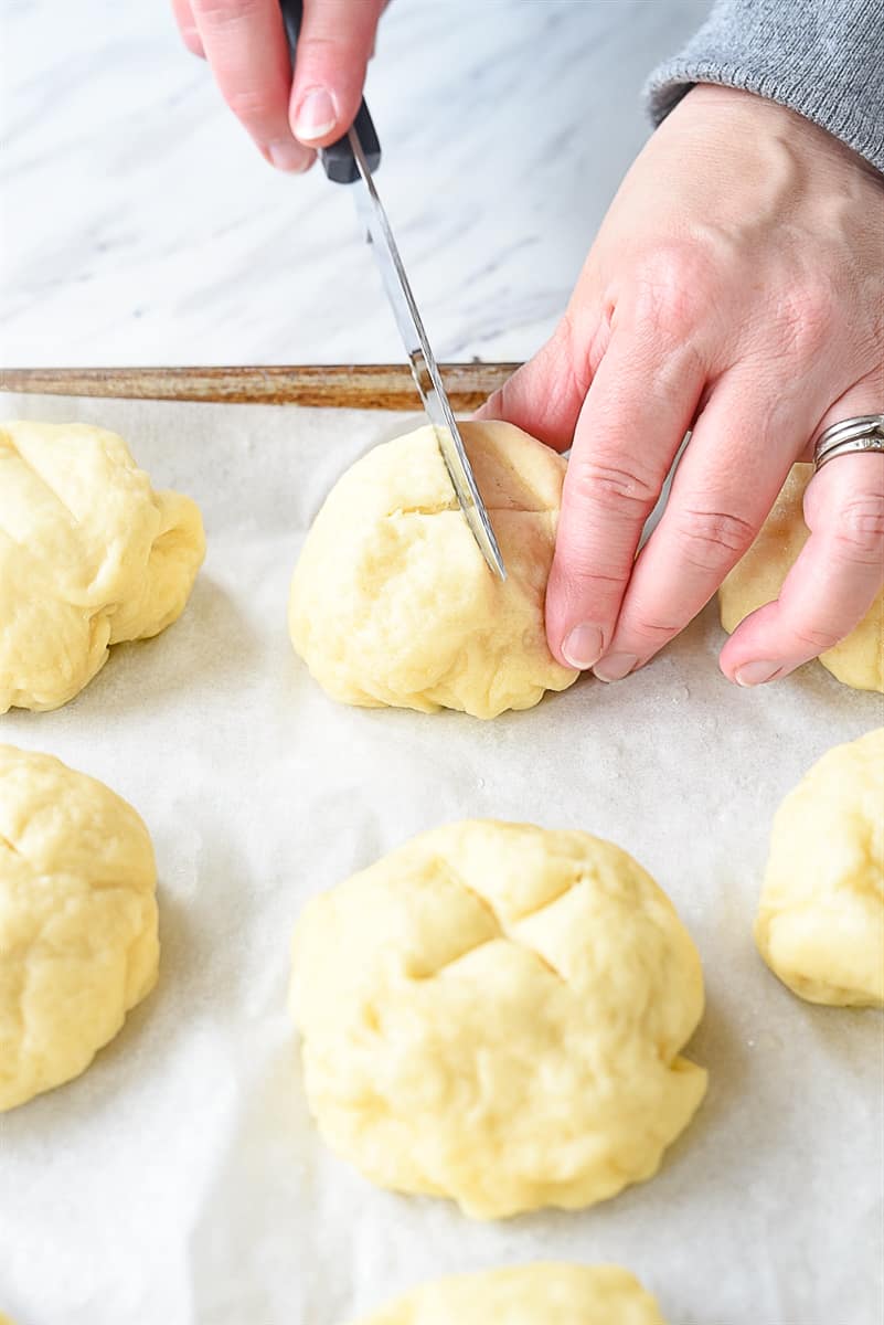 making a cut into pretzel rolls