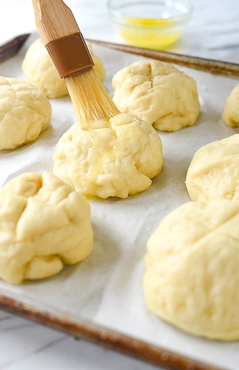 brushing pretzel rolls with melted butter