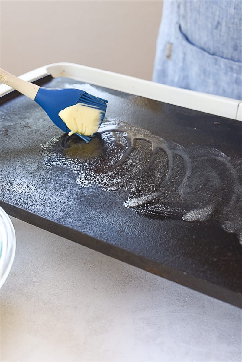 brushing griddle with butter