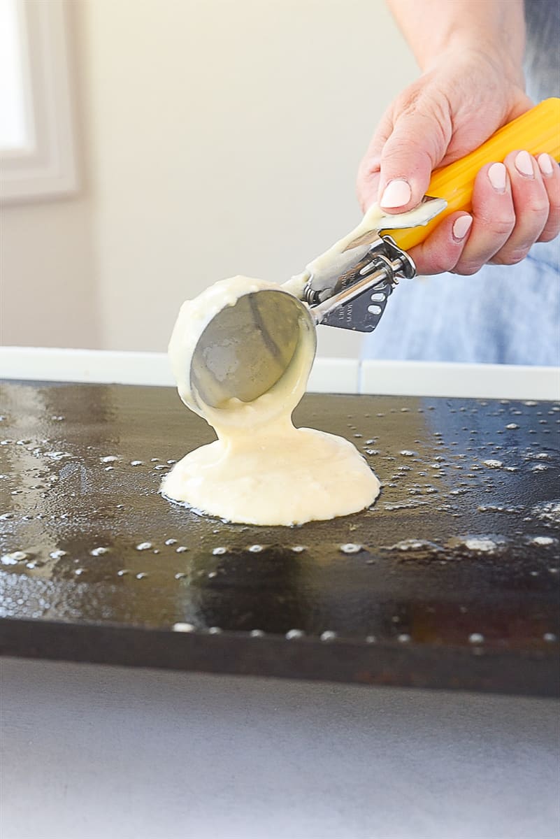 scooping pancake batter onto griddle