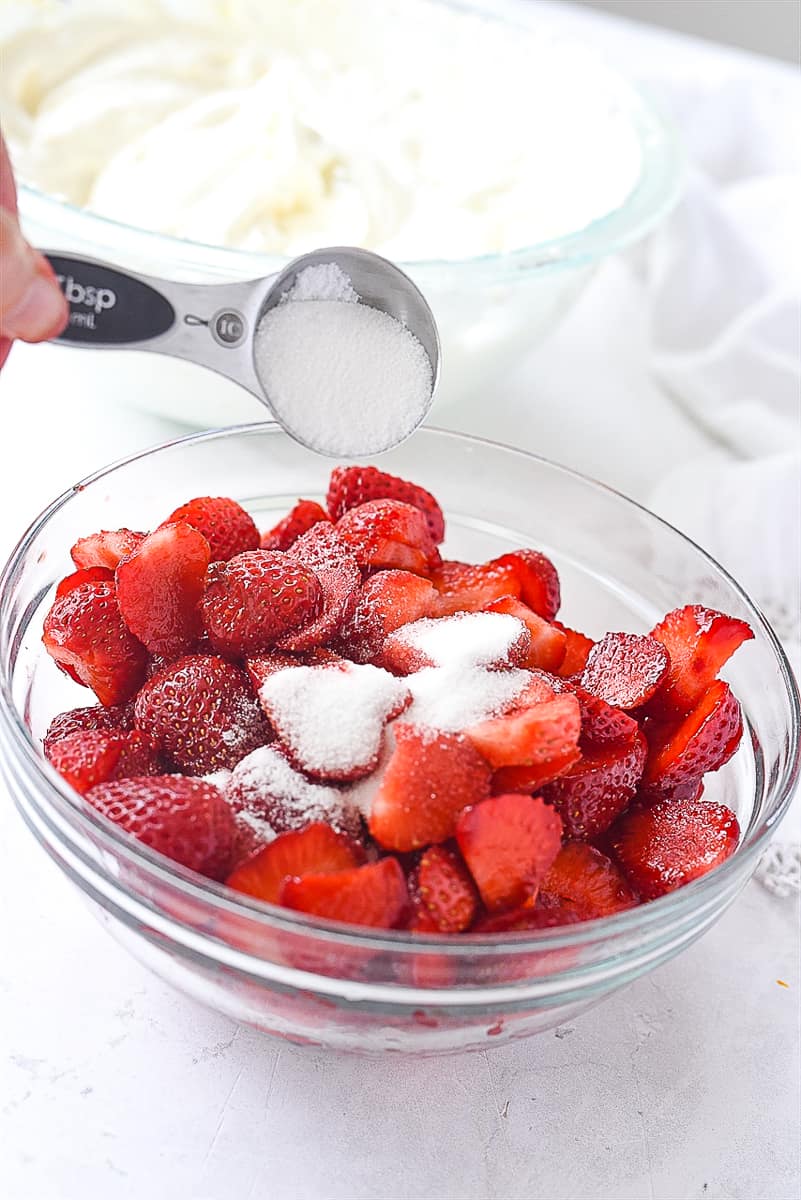 sprinkling sugar over strawberries