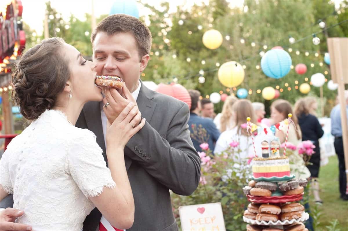 bride and groom eating a donut