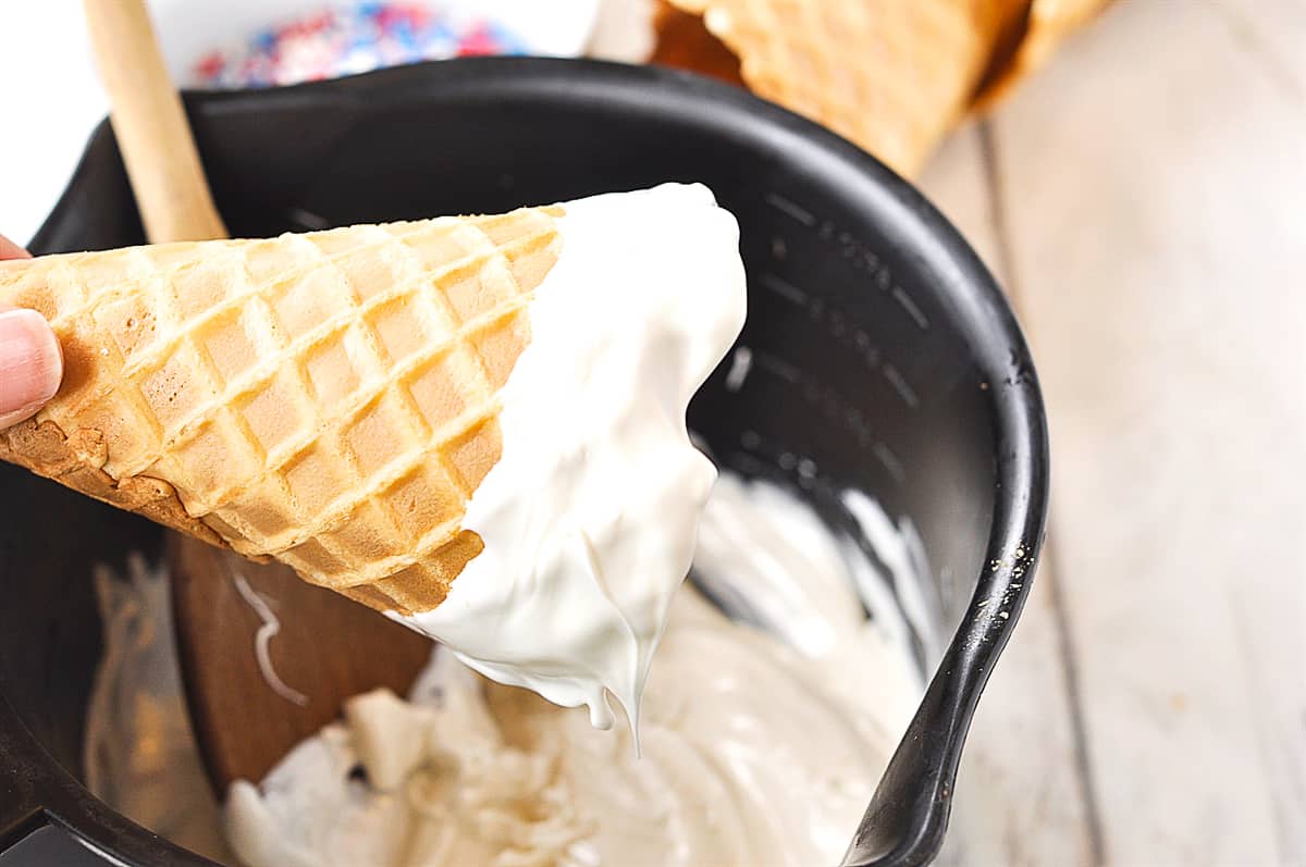 dipping waffle cone into chocolate