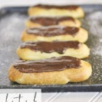 chocolate eclairs on a baking sheet