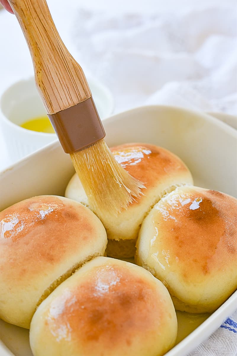brushing butter on rolls