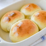 four baked rolls in a pan