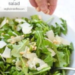 HAND ADDING NUTS TO A SALAD