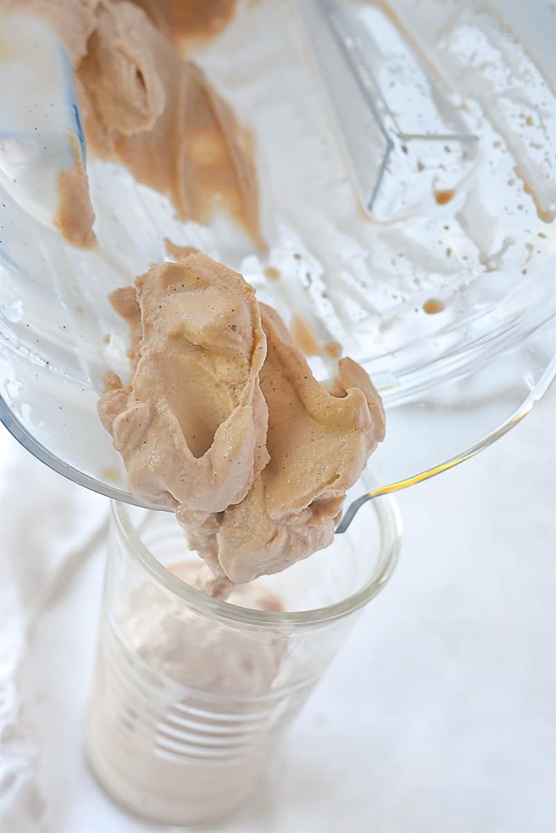 Pouring thick milkshake into glass