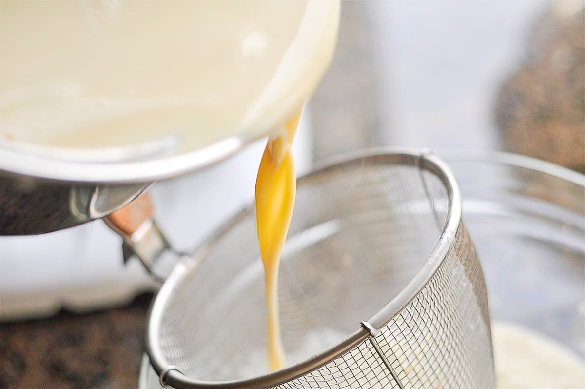 pouring milk through strainer
