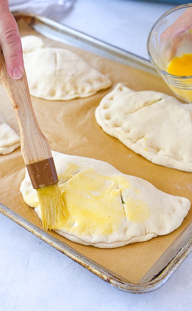 brushing calzone with egg