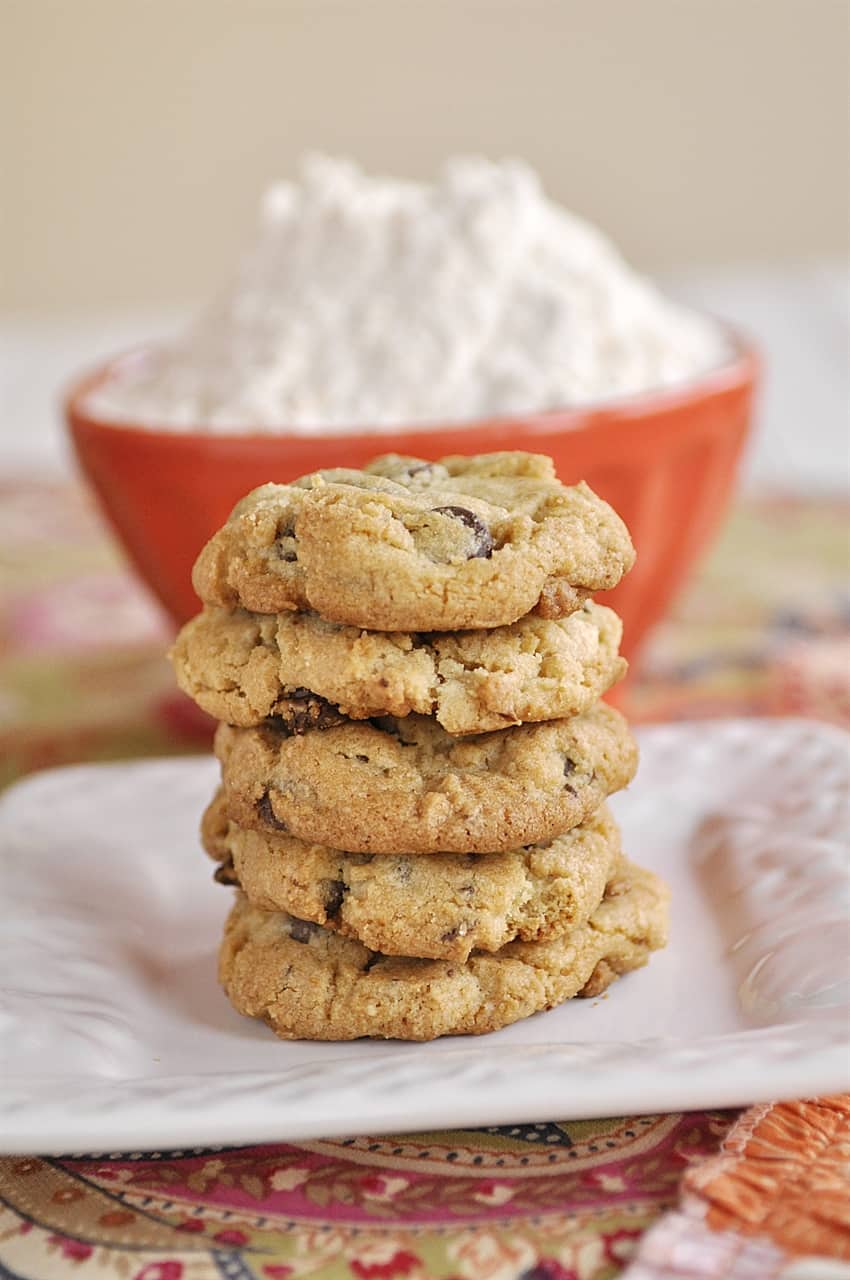 stack of cookies with a bowl of flour