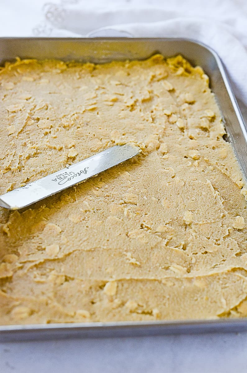 spreading peanut bars in pan