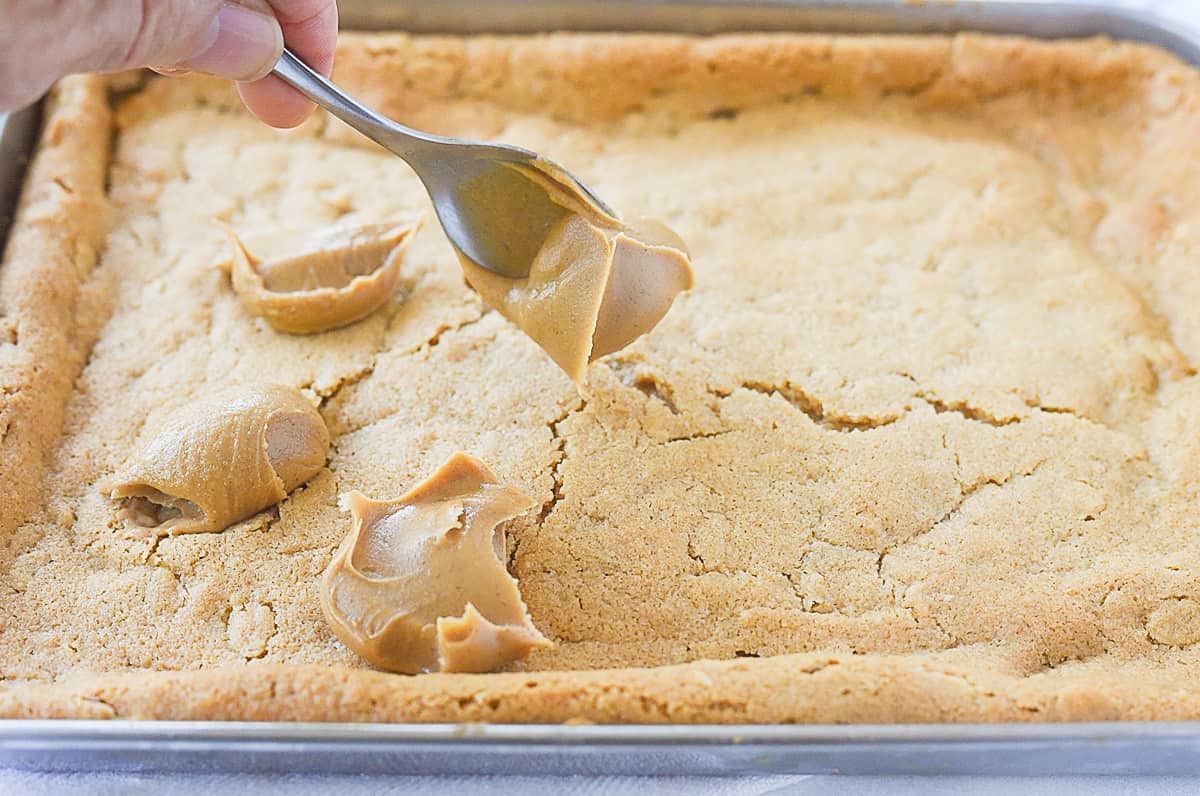 spooning peanut butter onto bars