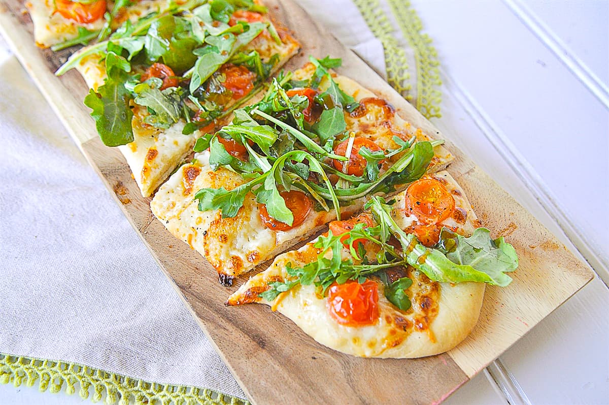flat bread pizza with arugula salad on it