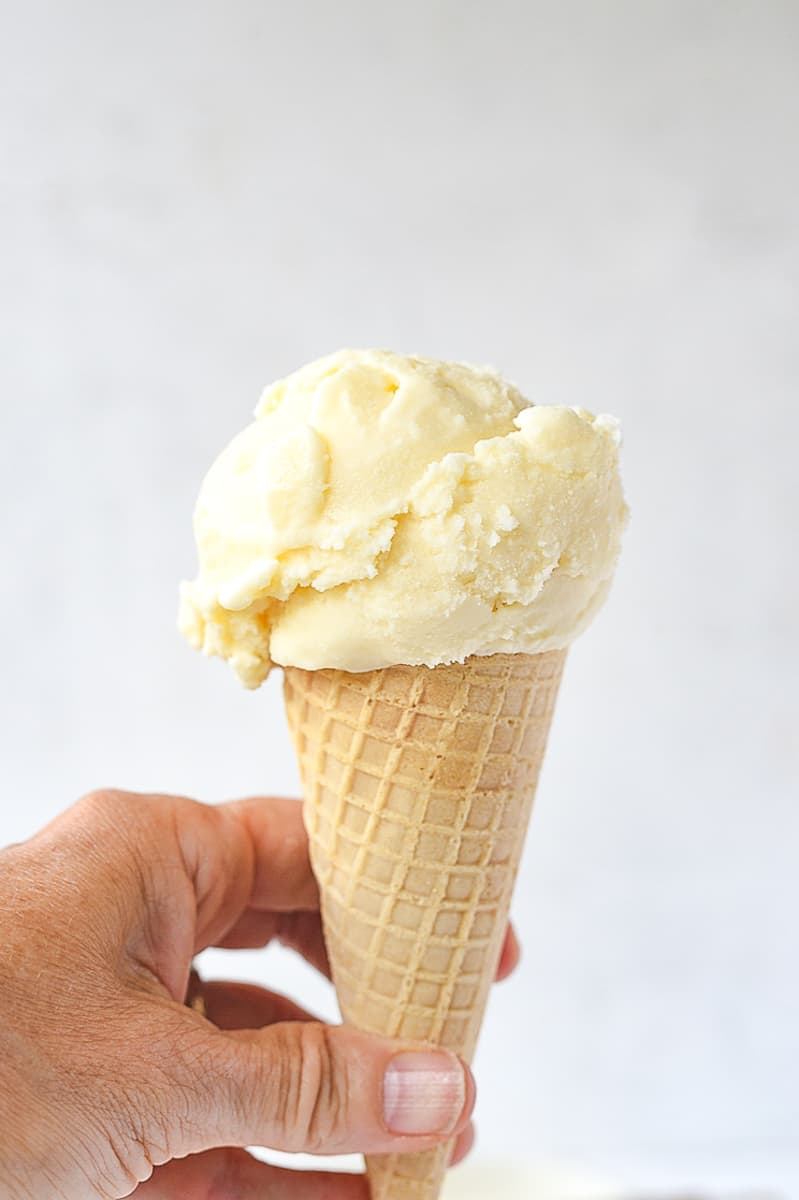 hand holding a creamsicle ice cream cone.